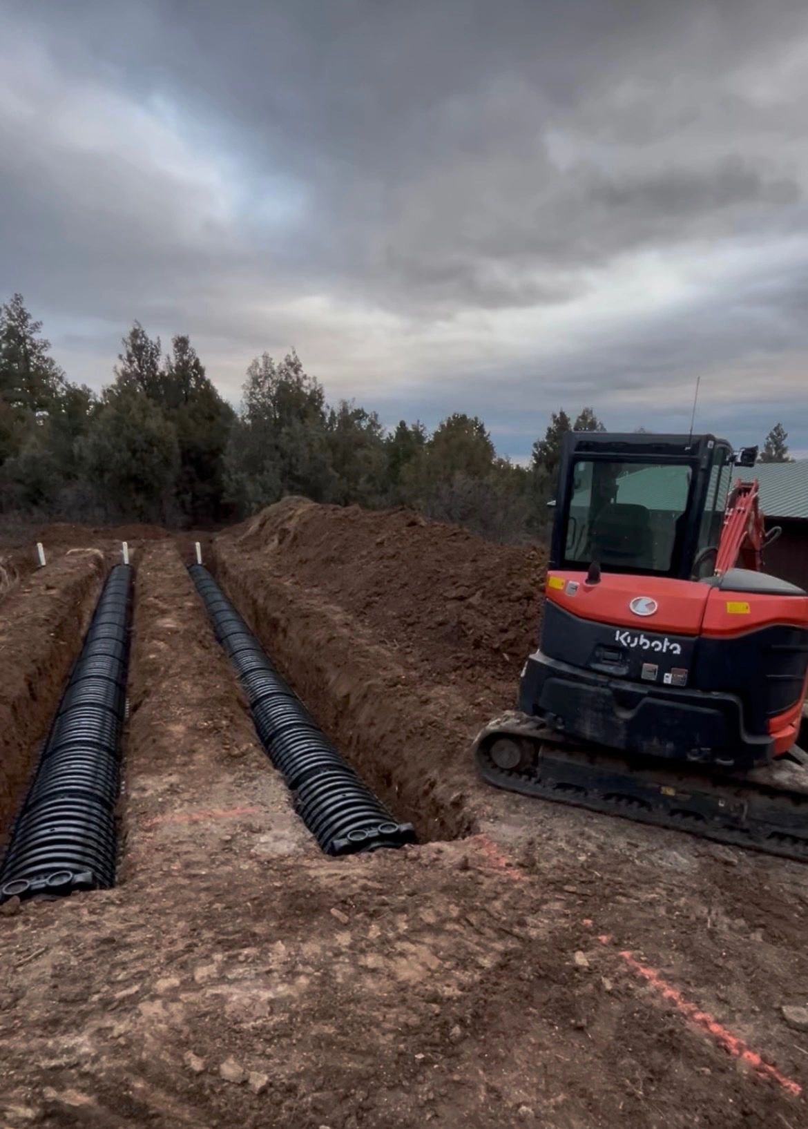 Kubota excavator laying drainage pipes